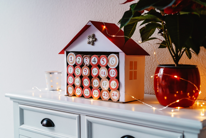 Handmade advent calendar house made from toilet paper rolls and carton. Sustainable Christmas, upcycling, zero waste, kids seasonal activities