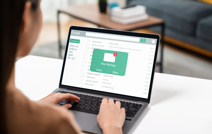 Woman using computer on table with new email message on laptop, communication connection message to global letters in the workplace