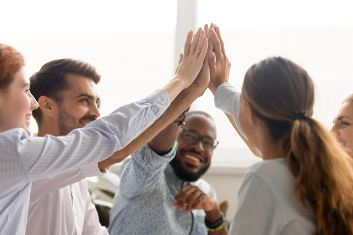 people group teammates hands give high five together promising unity as dream team concept, corporate success, teambuilding and loyalty, support in teamwork, coaching