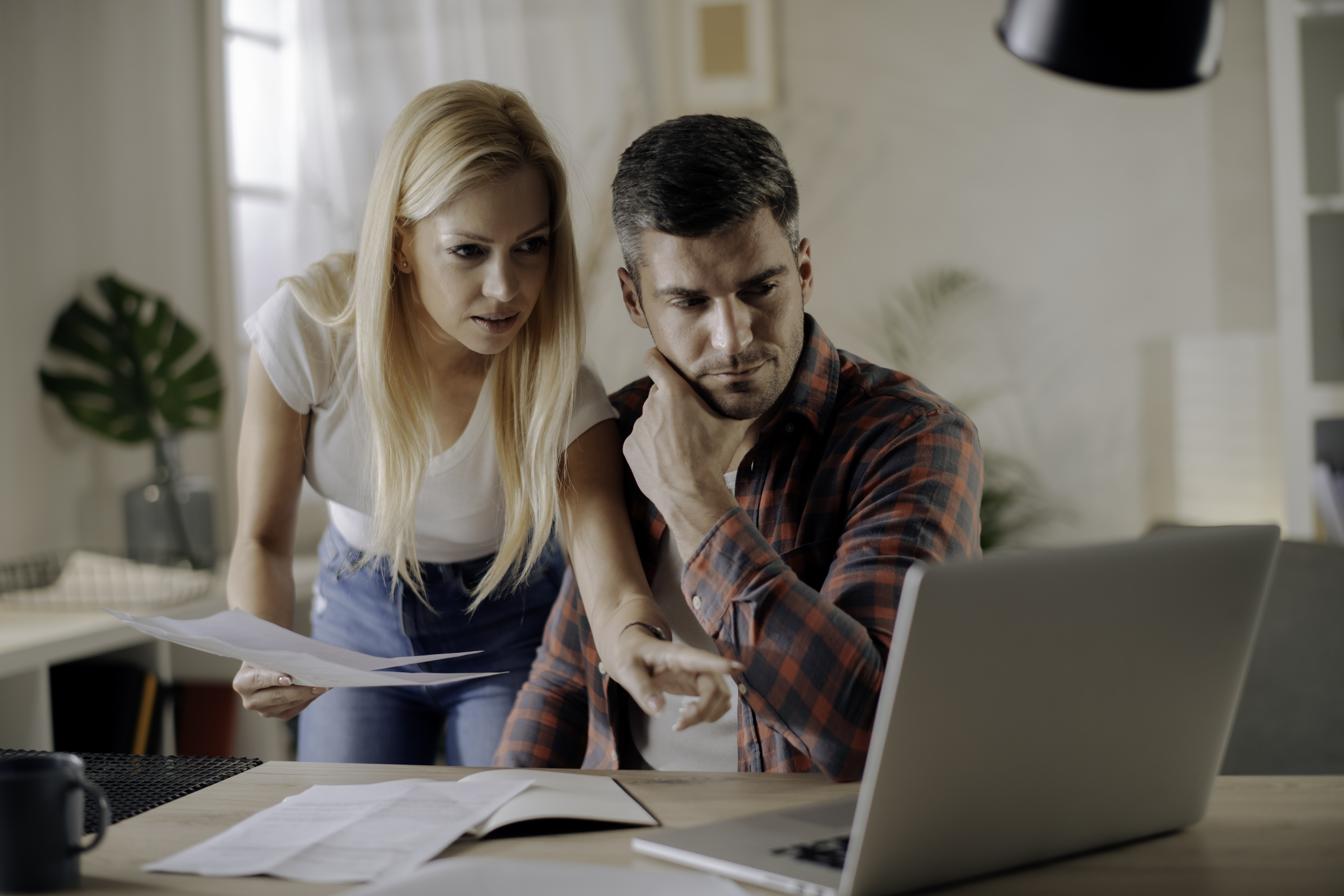 Worried young couple paying bills online in computer app stock photo