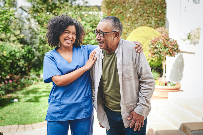 Nurse assisting older gentleman while walking