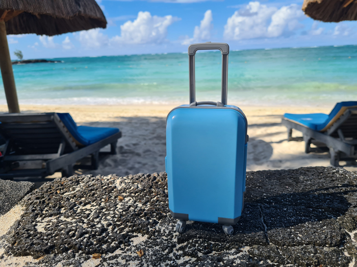 Travel suitcase on background of sea and ocean