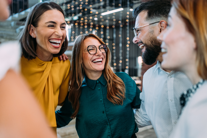 Excited coworkers embracing each other during a celebration in the office.
