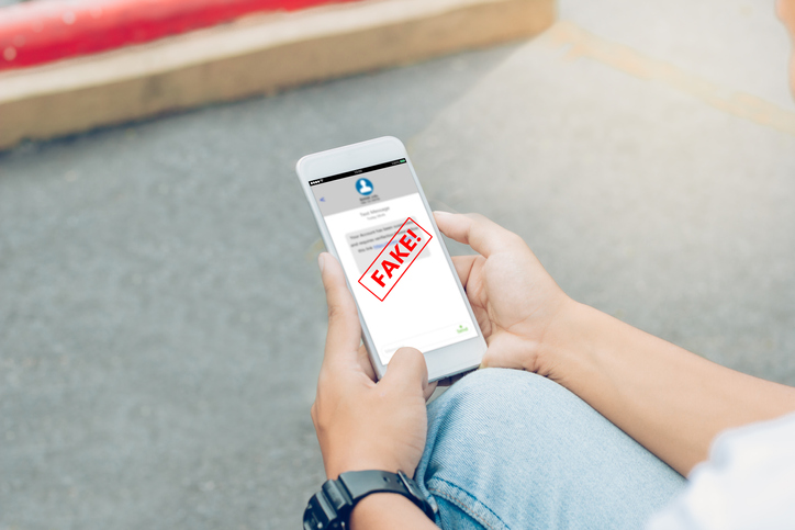 Man hands using smartphone showing a fake text