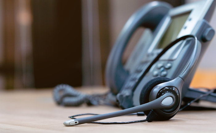 close up headset of call center and VOIP for communication technology on office table  in monitoring room for network operation job concept