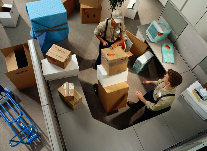 Overhead image of two movers packing up a room