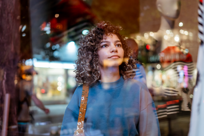false Young woman looking at clothing store