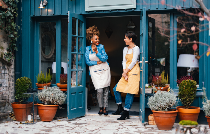 Portrait Of Two Smiling Colleagues Working Together In A Home Decor Store