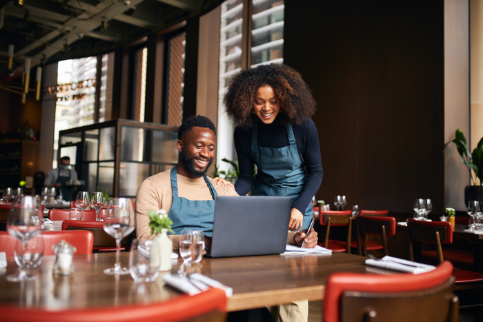 Restaurant managers working with laptop