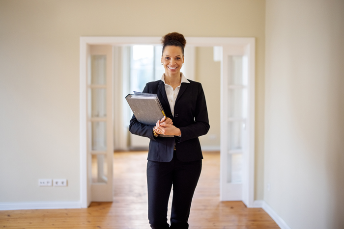 Portrait of smiling saleswoman with file at home