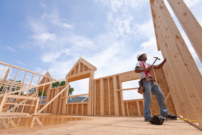 Hispanic carpenter working on the upper floor of a house under construction