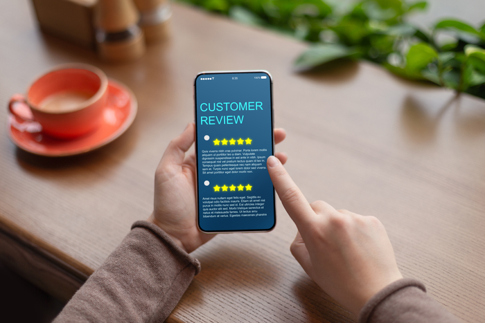 Woman looking for customer service on cellphone with the best five star rating
