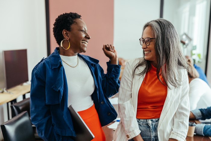 Creative colleagues laughing in a vibrant and colorful workplace