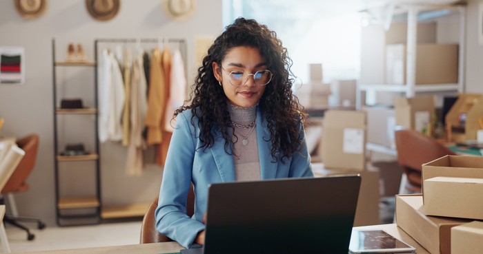false Woman, fashion and designer with laptop in logistics, research or small business management at boutique. Female person or entrepreneur with computer for inventory or storage check at retail store