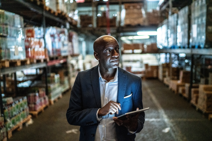 Mature man using the digital tablet in a warehouse