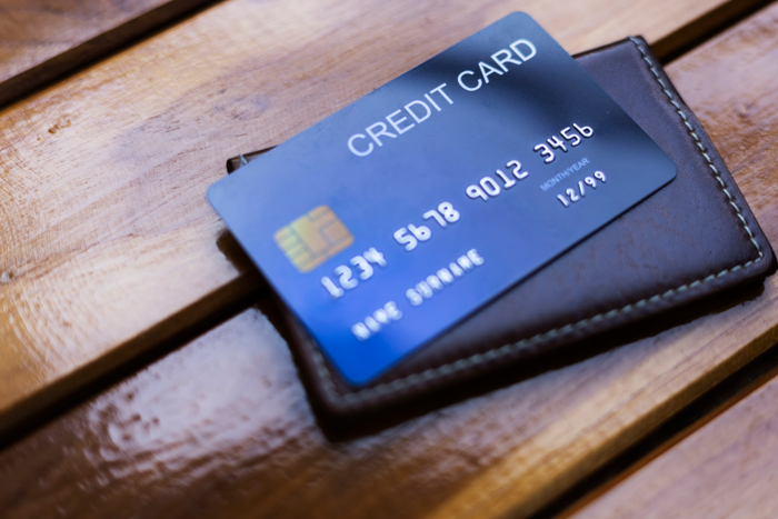 Wallet and blue credit card on wooden background