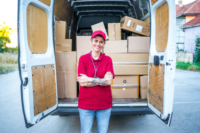 Female courier in front of a delivery van