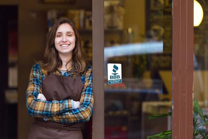 business woman standing in doorway of BBB accredited business