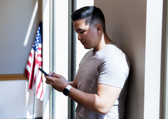 Mid adult veteran takes time from meeting to text wife