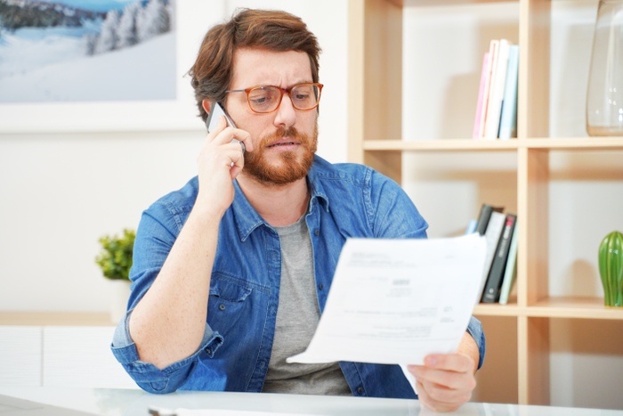 Man calling customer service after unjustified costs complain