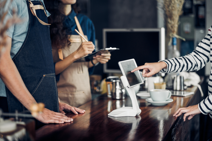 customer self service order drink menu with tablet screen at cafe counter bar,seller coffee shop accept payment by mobile.digital lifestyle concept.Blank space for display of design.