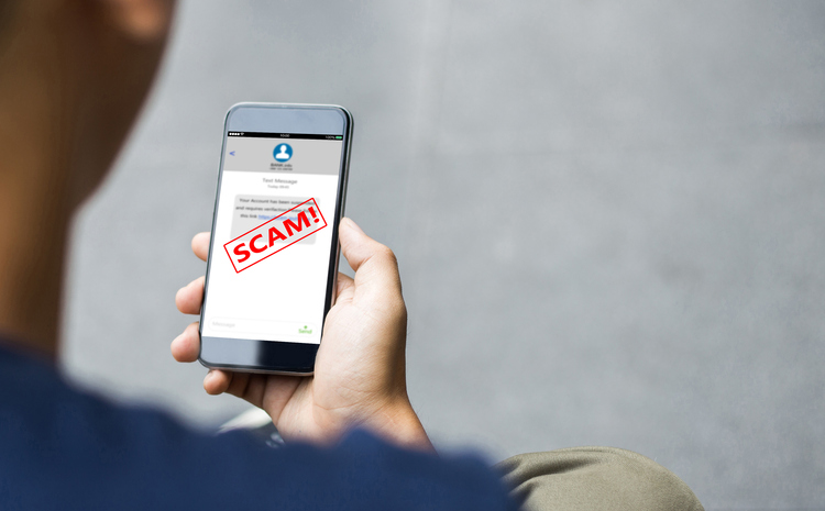 cell phone with a text message and the word scam in bold red letters