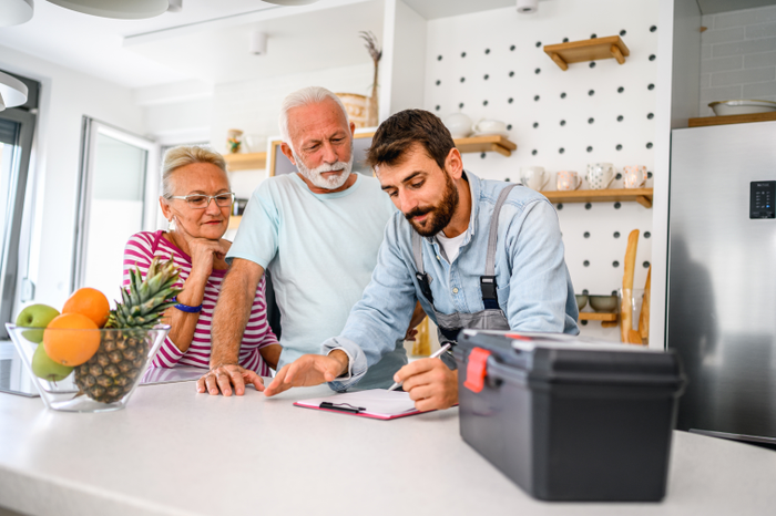 Repairman gives repair estimate to a senior couple