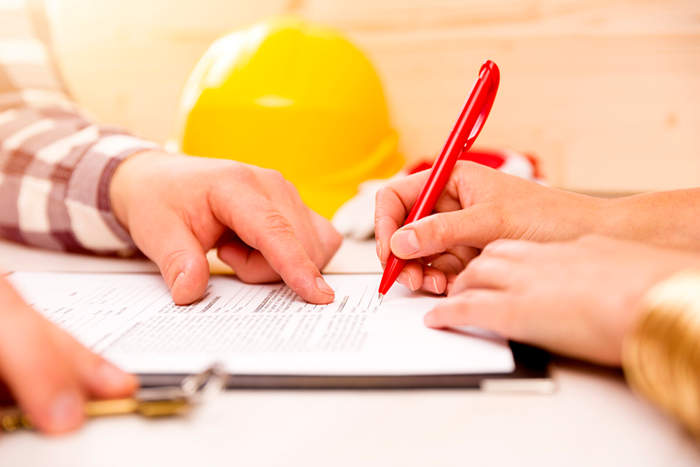 Woman signing construction contract with contractor to build a house