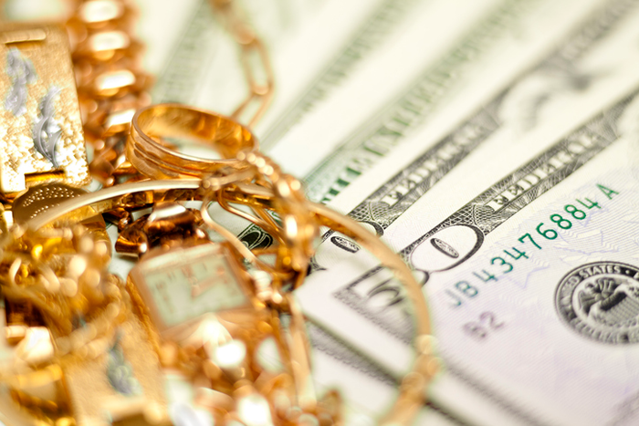Closeup of gold jewelry and money