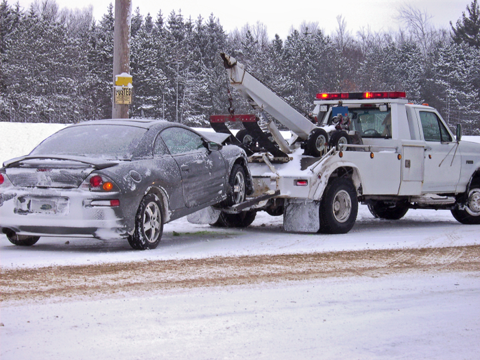 Truck towing car on snowy road