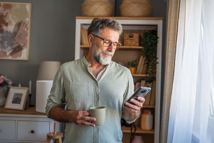 Man drinking coffee and using phone