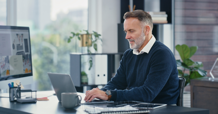 false Mature ceo, typing and working on laptop in his office. Corporate business man busy using computer to email colleagues. Committed and professional worker uses tech for efficient communication.