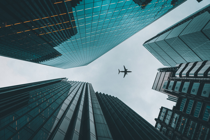 Plane flying over buildings in London Liverpool street.