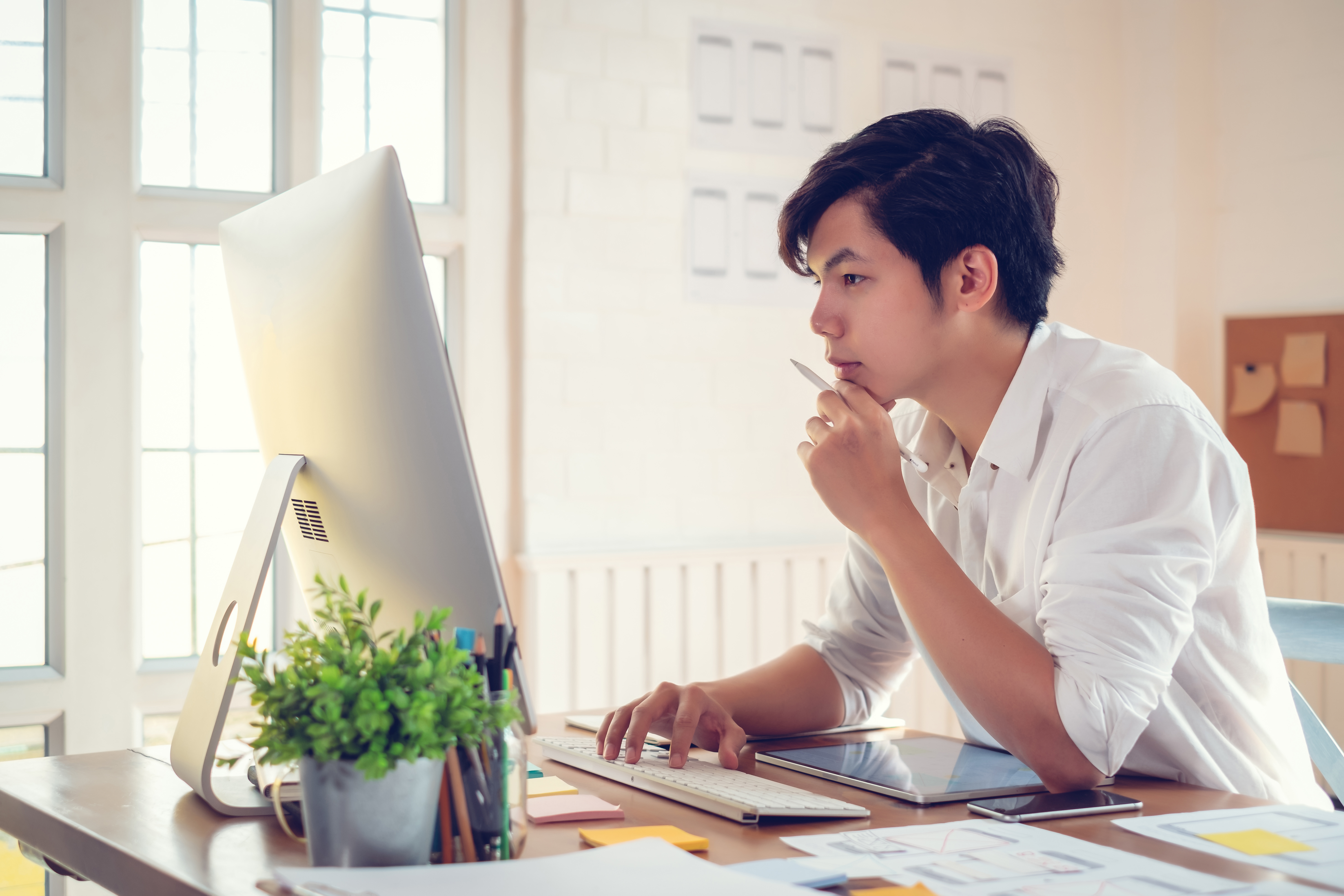 Young asian man designer planning develop application develop for mobile phone at home.