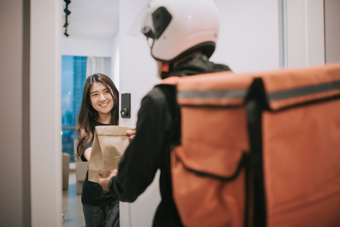 asian chinese delivery man with helmet  press door bell for grocery food delivery