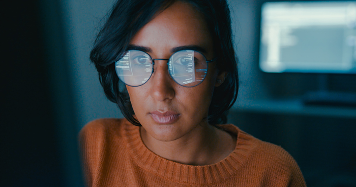 Female computer programmer works on complex software development tasks at her home office late into the night. Software developer, artificial intelligence and programming.