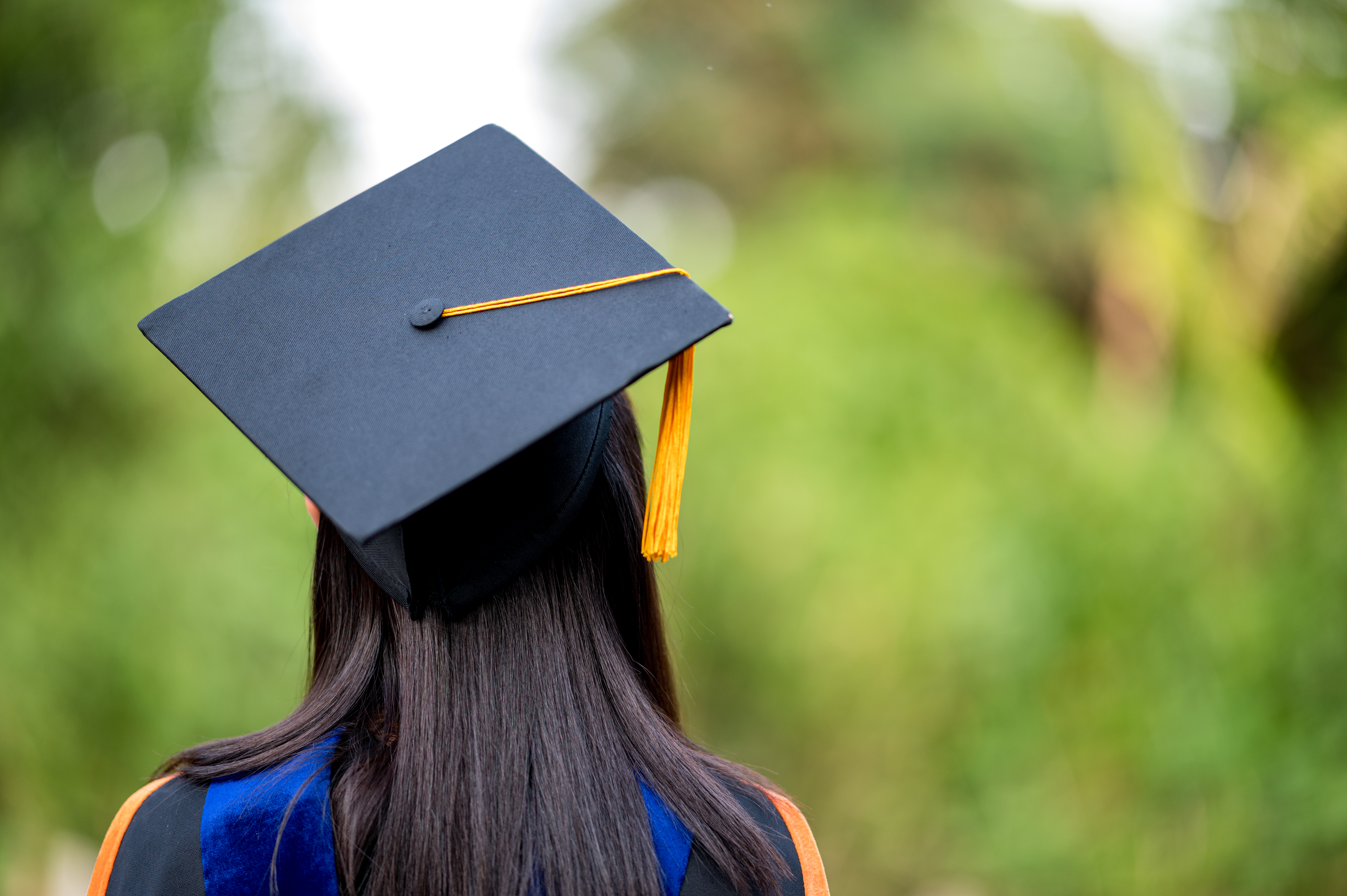 closeup behind a female college graduate in cap and gown